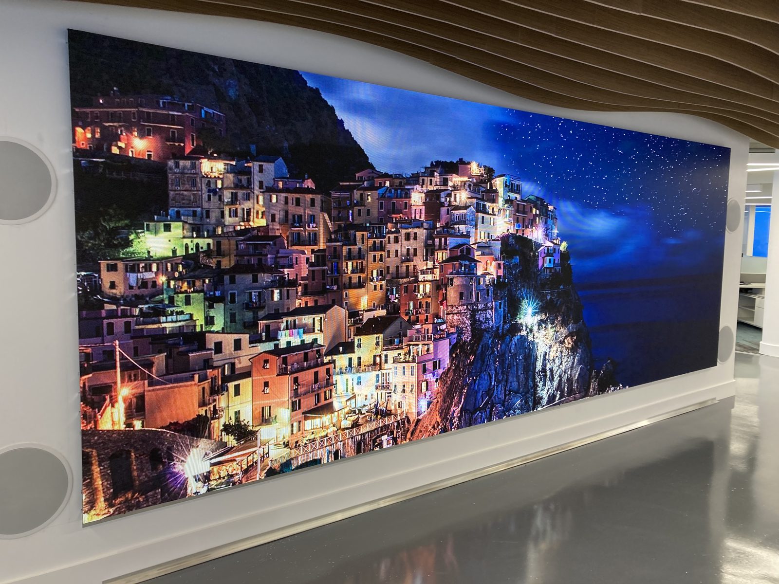 Curved fine-pitch LED video wall at Ocean Bank showing a vivid coastal village at night, installed by Ultra LED